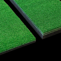 Two green artificial golf grass panels on a black background
