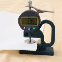 Digital dial indicator measuring a piece of white impact screen