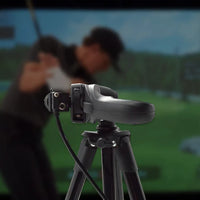 Camera on a tripod with a blurred background of two people and a scenic view.