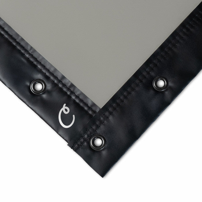 Black corner of a tarp with grommets on a gray background