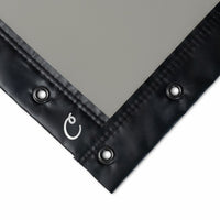 Black corner of a tarp with grommets on a gray background